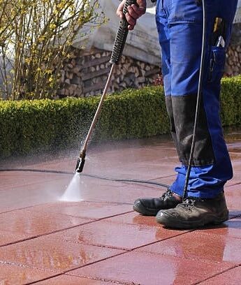 A person is Power washing the floor.